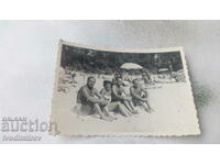 Foto Femeie și trei bărbați pe plajă