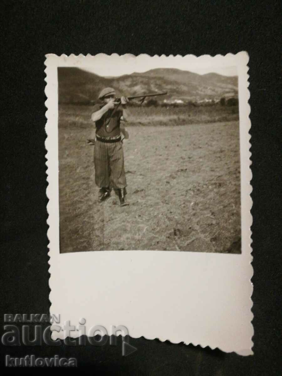 Fotografie veche a unui vânător cu o pușcă