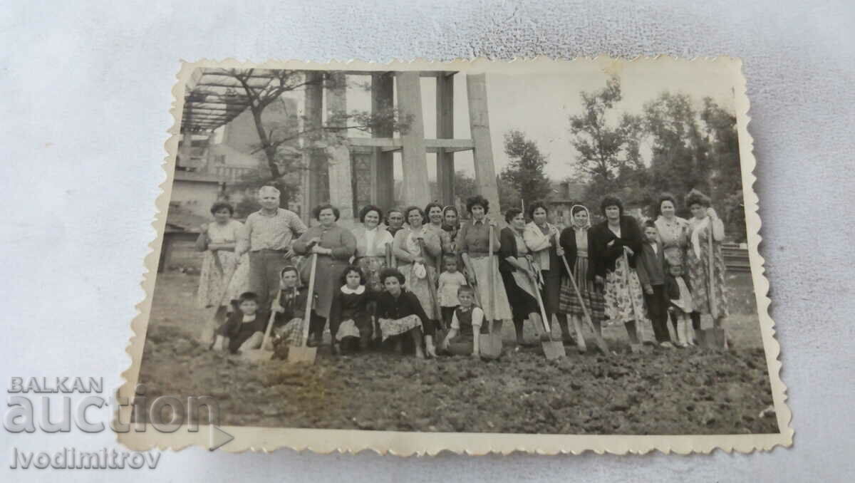 Photo Man and women with shovels