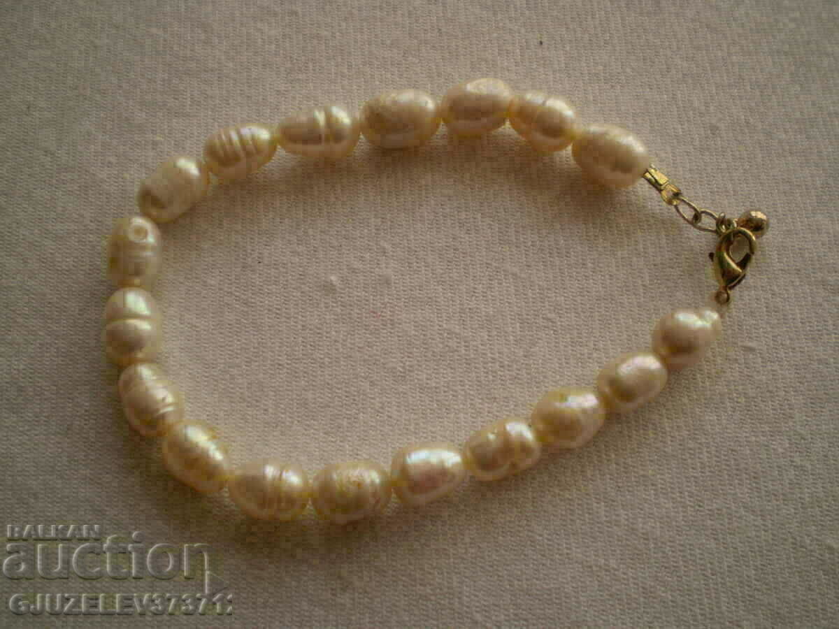 Delivery of bracelet made of natural white river pearls is made by hand Delivery of bracelet made of natural white river pearls is made by hand