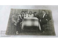 Fotografie Băieți și fete în jurul unei mese în curtea unei case 1929