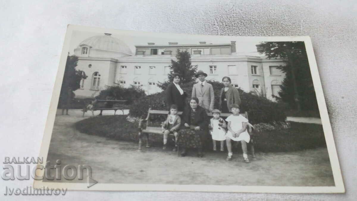 Φωτογραφία Οικογένεια Kyustendil σε ένα παγκάκι στο πάρκο μπροστά από το μπάνιο