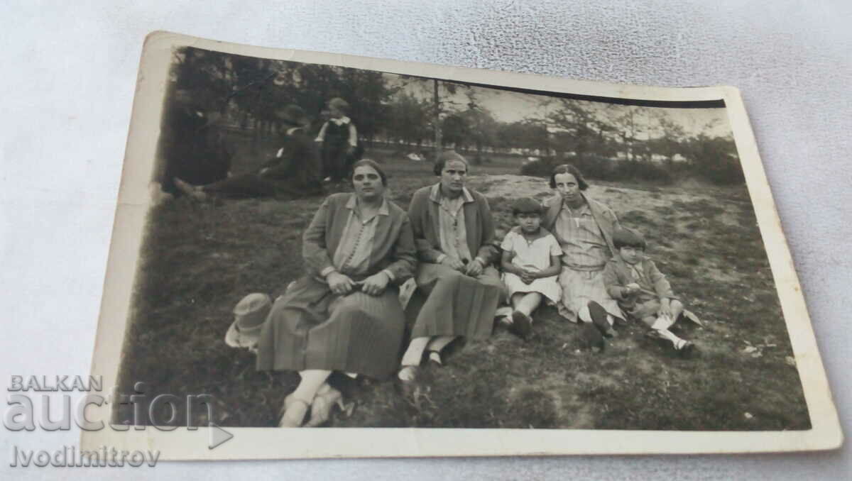 Φωτογραφία Τρεις γυναίκες και δύο παιδιά στο γρασίδι