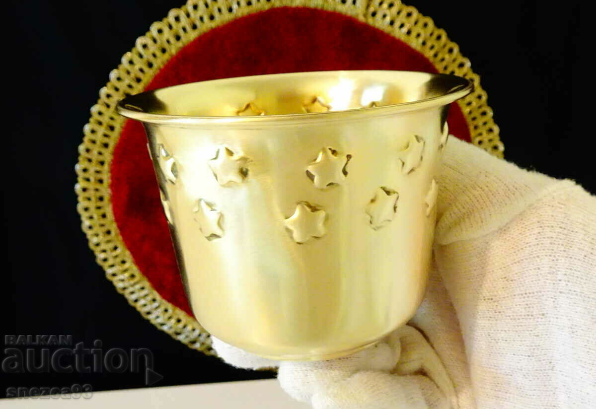 Brass cup with embossed stars.
