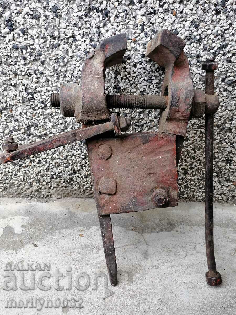 An old vise clamps a hardware tool