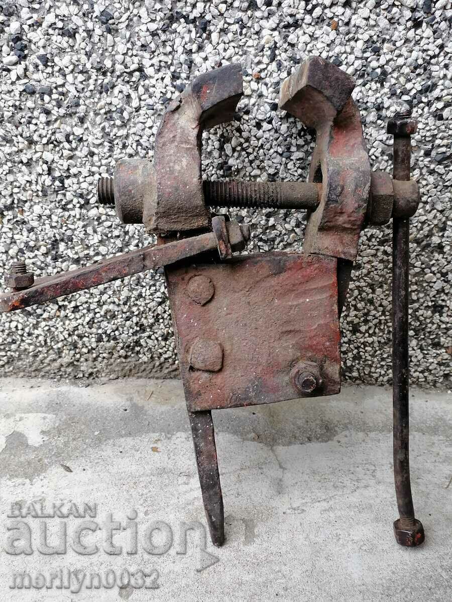 An old vise clamps a blacksmith's tool An old vise clamps a blacksmith's tool