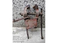 An old vise clamps a blacksmith's tool