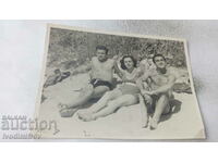 Foto Femeie și doi bărbați pe plajă