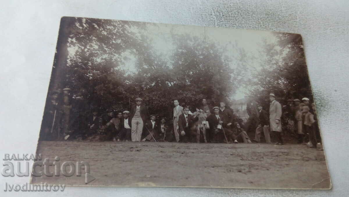 Foto Grup de bărbați cu un măgar