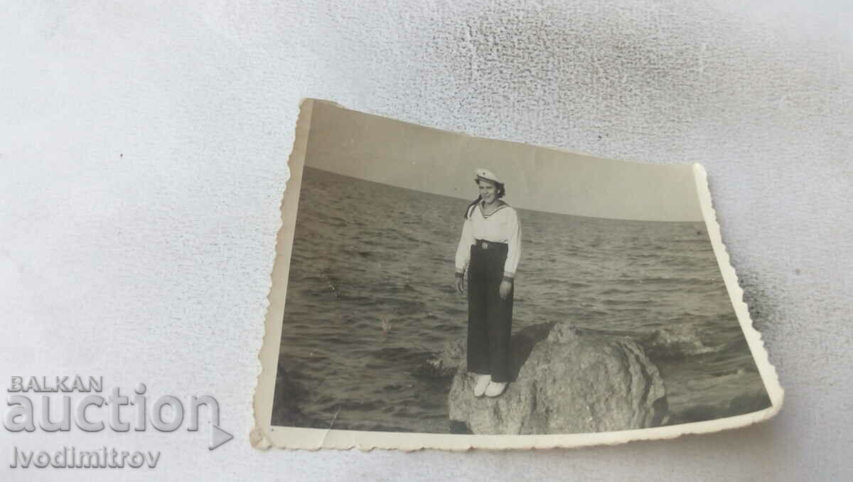 Fotografie Fată tânără într-o uniformă de marinar pe o piatră