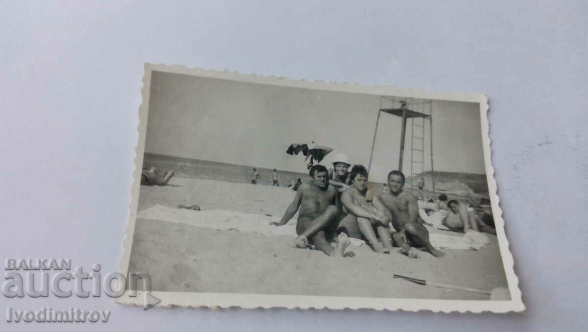 Foto Doi bărbați și două femei pe plajă