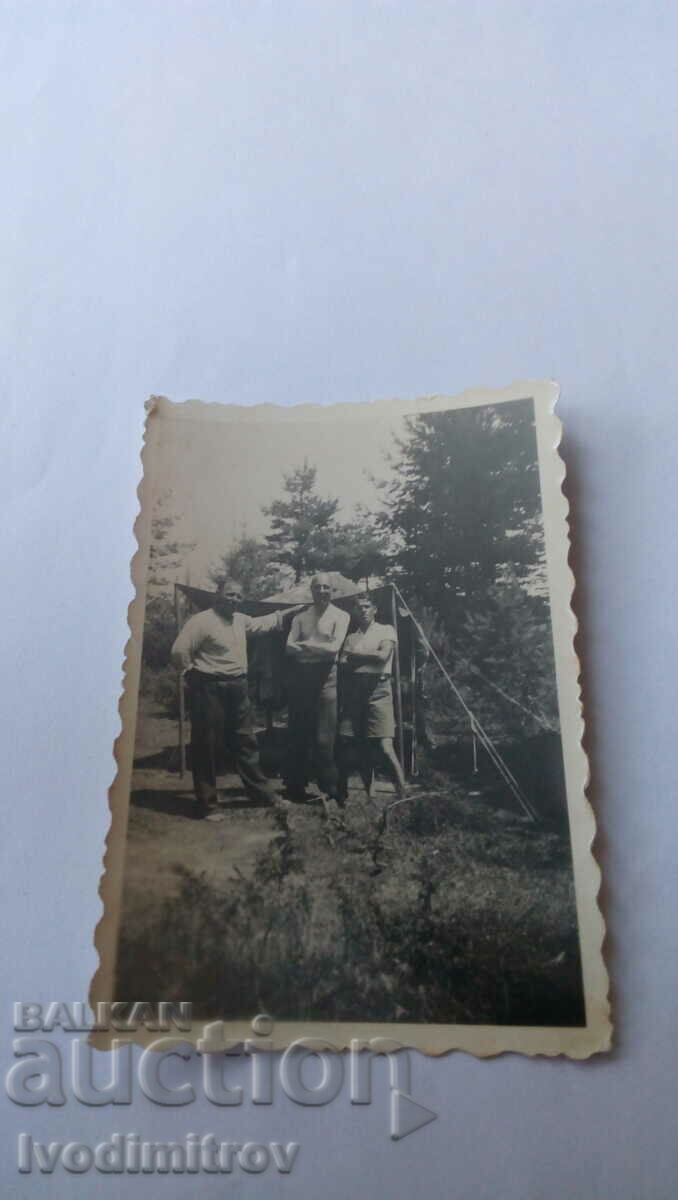 Φωτογραφία Τρεις άνδρες μπροστά από μια τέντα με μουσαμά στα βουνά