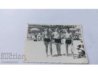 Photo Three men in swimsuits on the beach