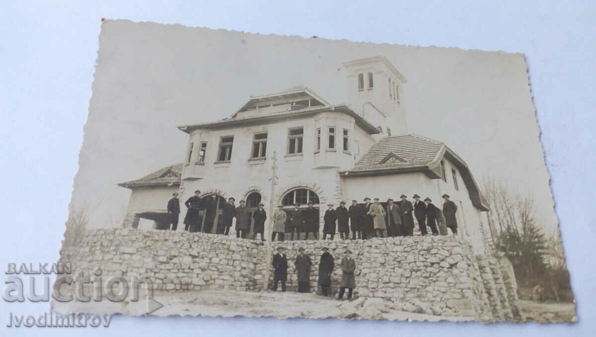 Photo Men in front of a building in the mountains