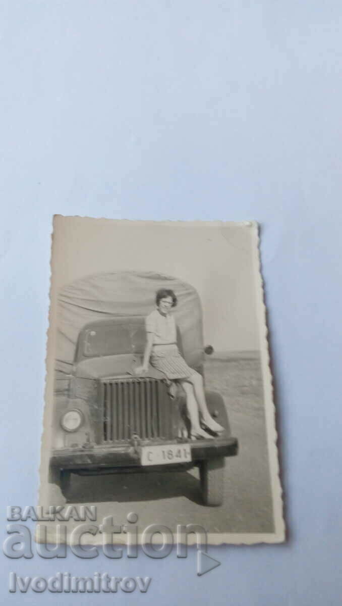 Photo Woman on the hood of a retro truck with registration number № Since 1841