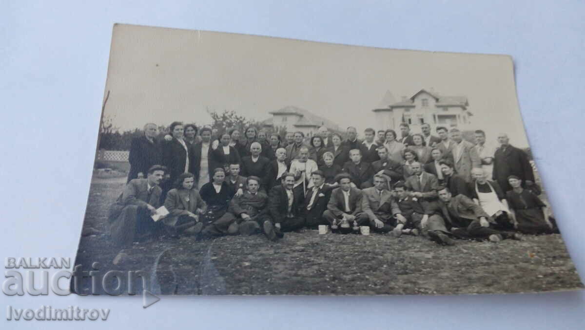 Foto Bărbați și femei în fața unui grup de vile