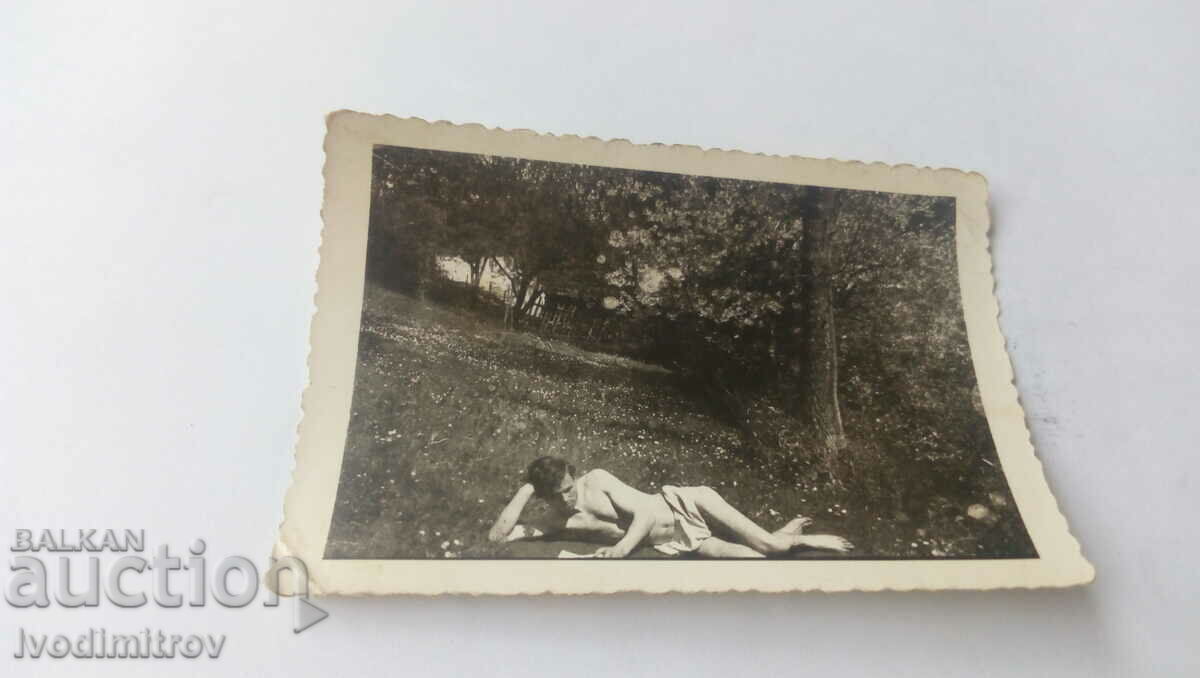 Снимка Мъж по гащи чете книга на тревата