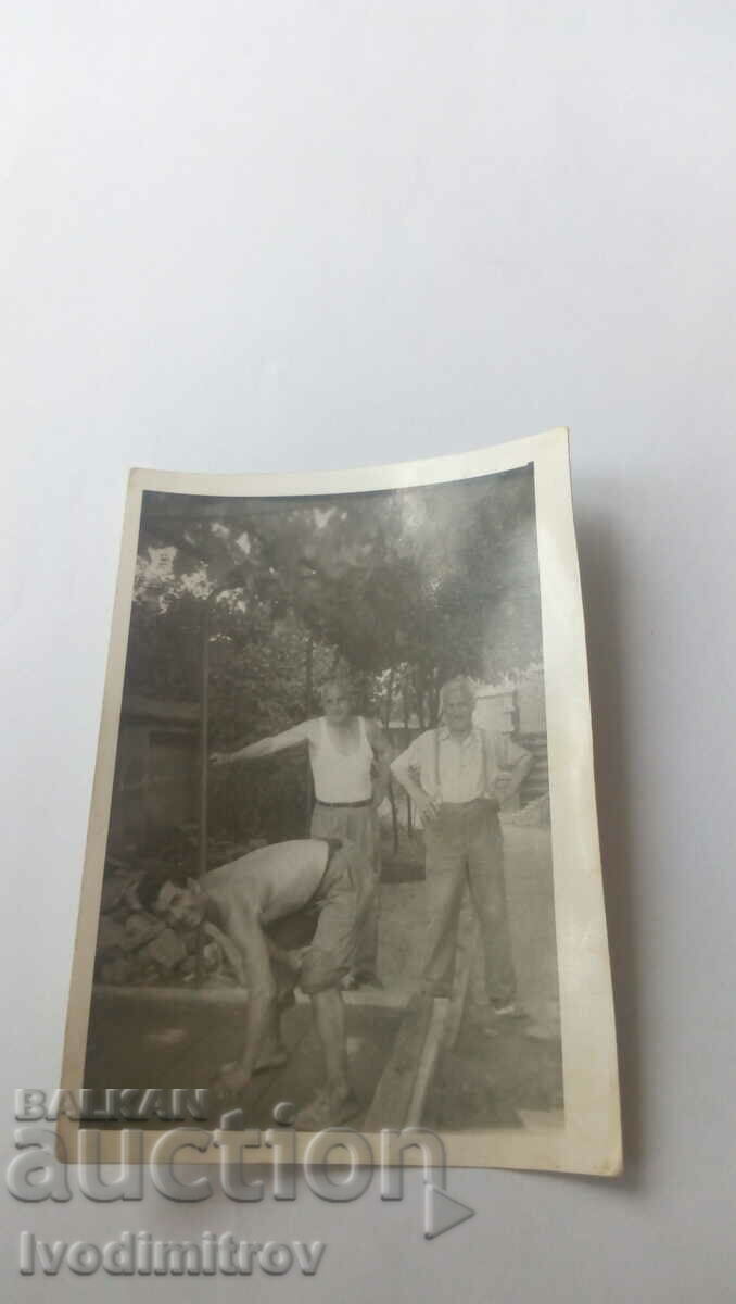 Photo Three men in the yard of the house