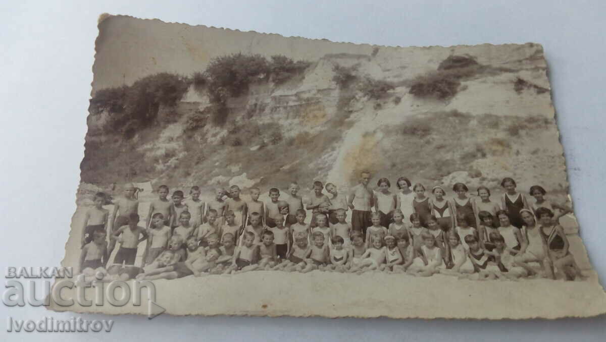 Снимка Момчета и момичета със своя възпитател на плажа