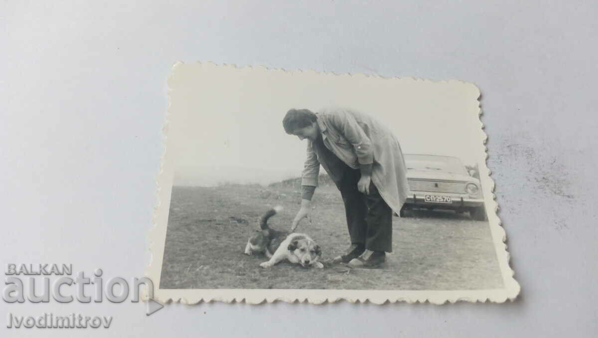Foto Bărbat cu un câine și o Lada