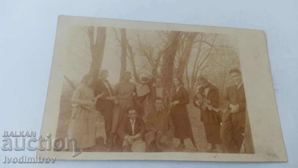 Photo Young men and women with guitar and tambourine in the woods