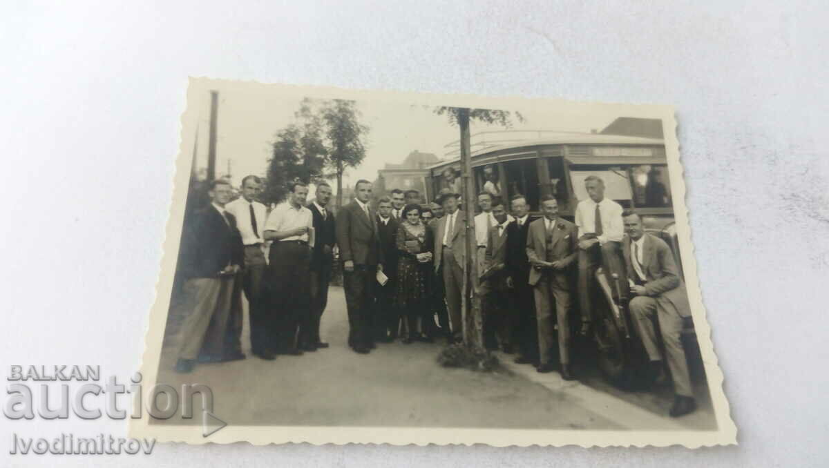 Foto Bărbați și femei lângă un autobuz retro