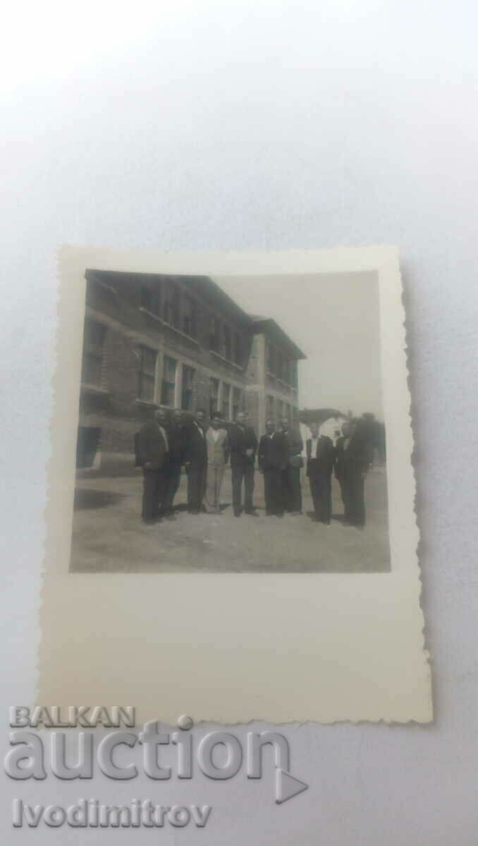 Foto Bărbați în fața unei clădiri nou construite