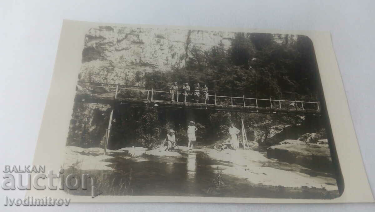 Photo Men and women on a bridge over a river