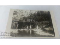 Photo Men and women on a bridge over a river