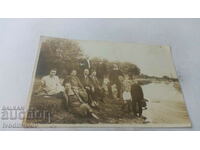 Photo Men women and children along the river