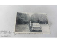 Fotografie Un bărbat lângă o mașină de epocă PEUGEOT