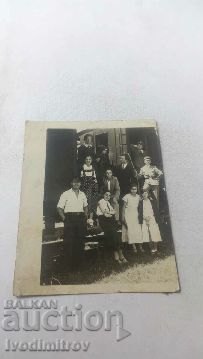 Photo Young men and women next to two railway cars