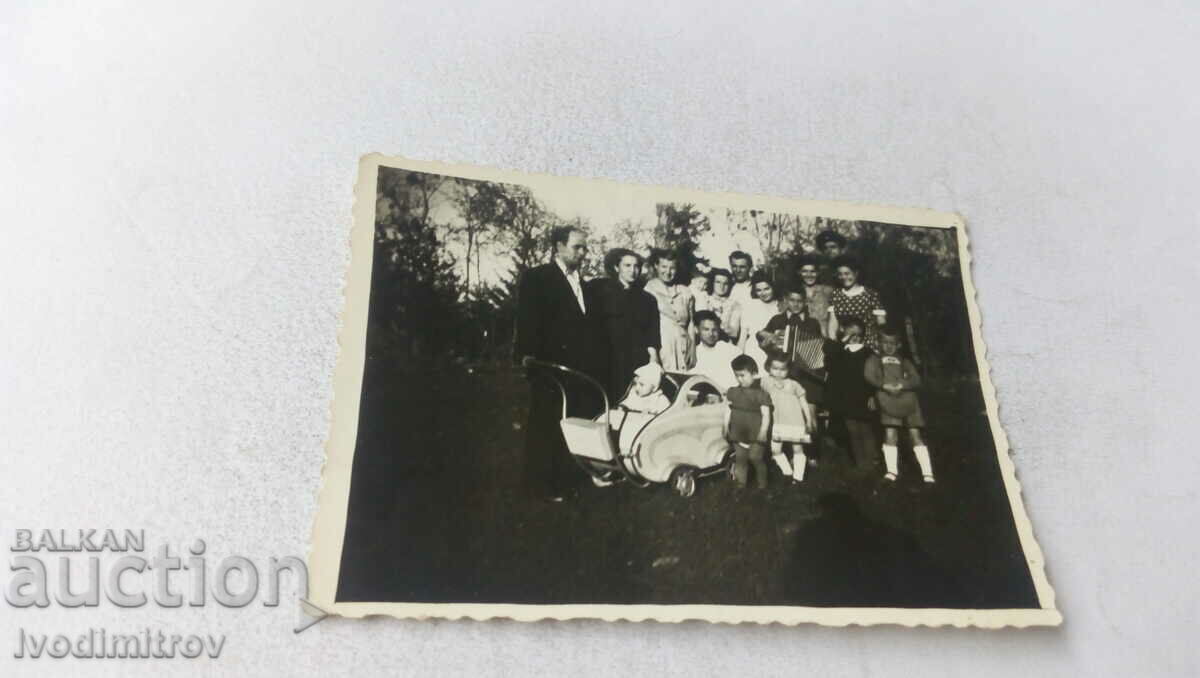 Φωτογραφία Άνδρες γυναίκες παιδιά και ένα μωρό σε ένα vintage καροτσάκι