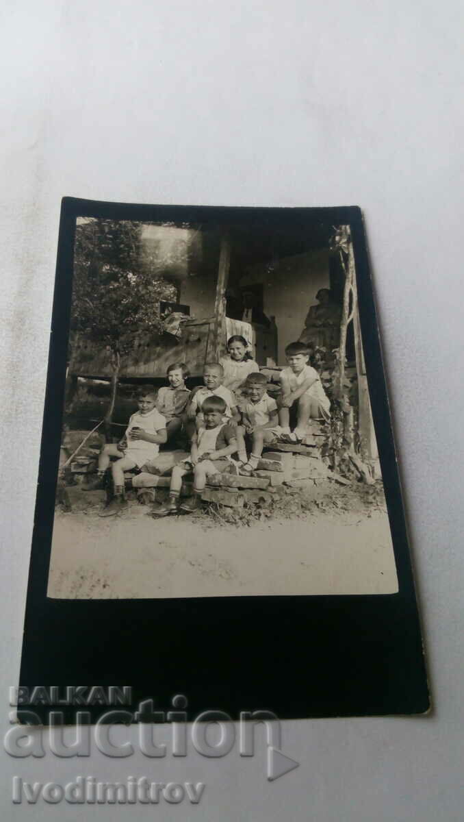 Φωτογραφία Αγόρια και κορίτσια στις σκάλες ενός παλιού σπιτιού