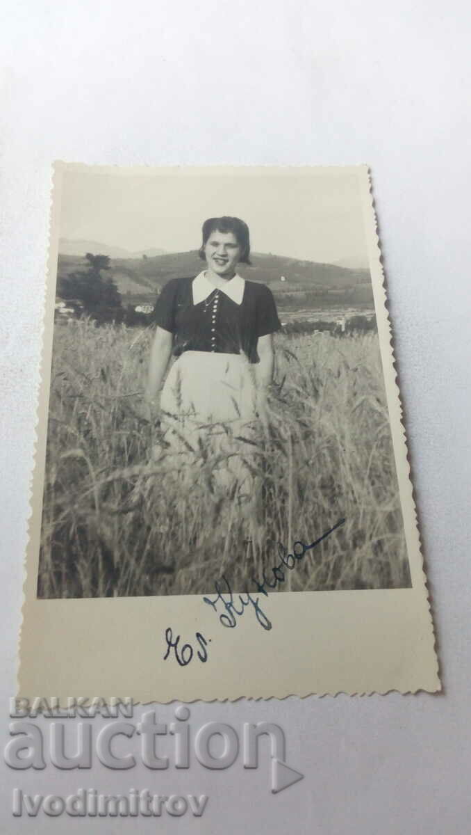 Photo Young girl among wheat ears