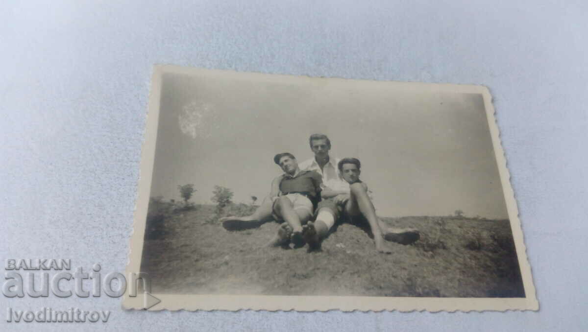 Photo Three young men lay on the ground