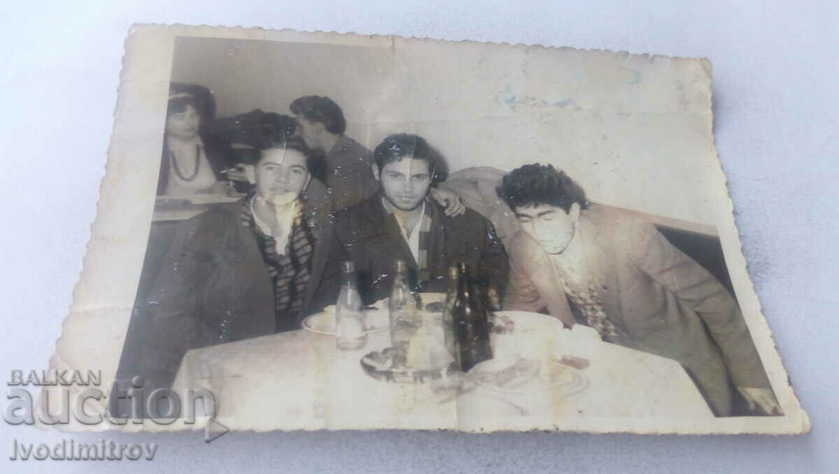 Φωτογραφία Τρεις νεαροί άντρες που πίνουν ένα ποτό