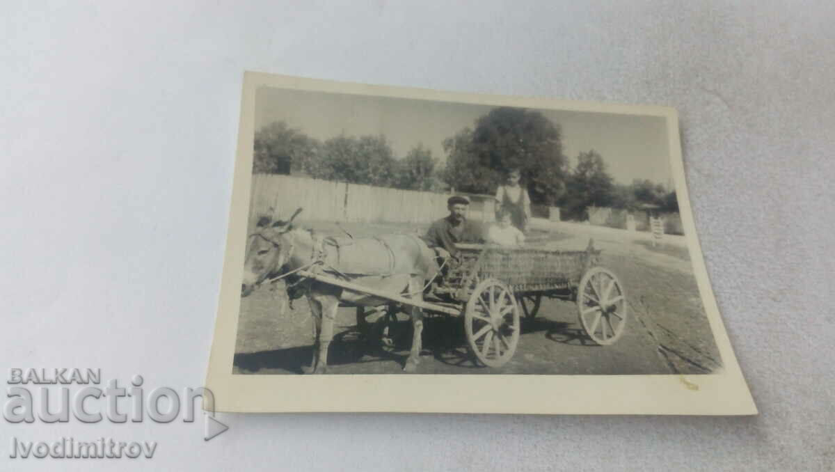 Photo A man and two children with a donkey cart