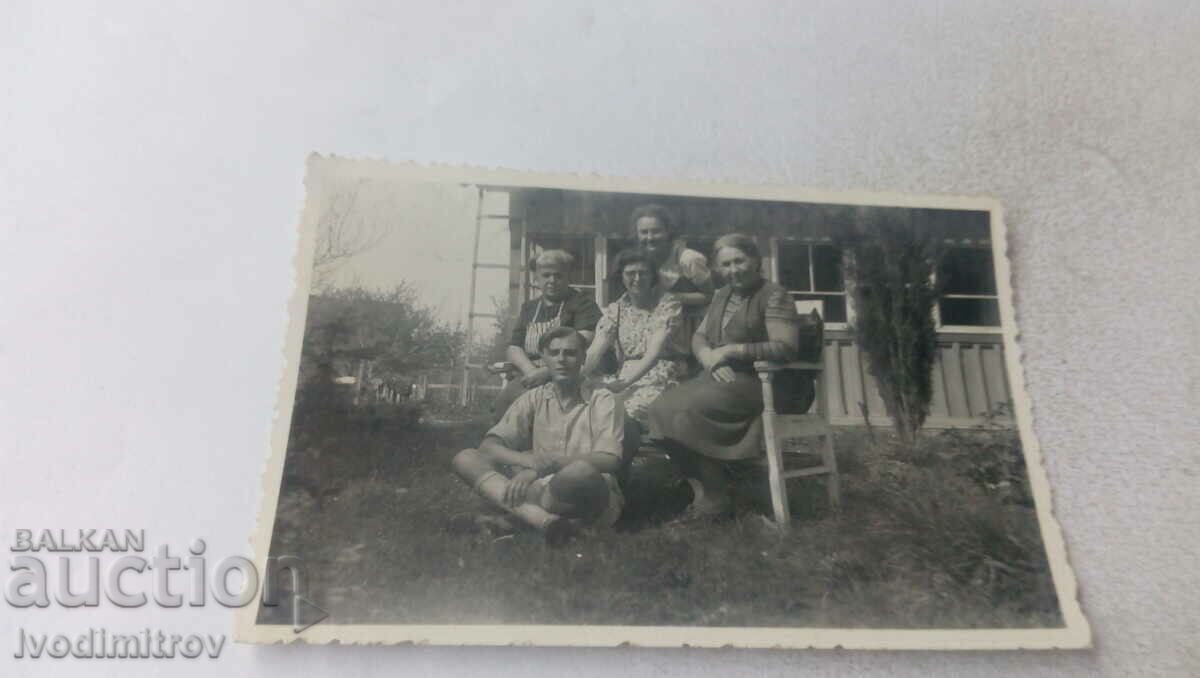 Photo A young man and four women on a bench in the yard