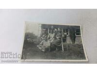 Photo A young man and four women on a bench in the yard