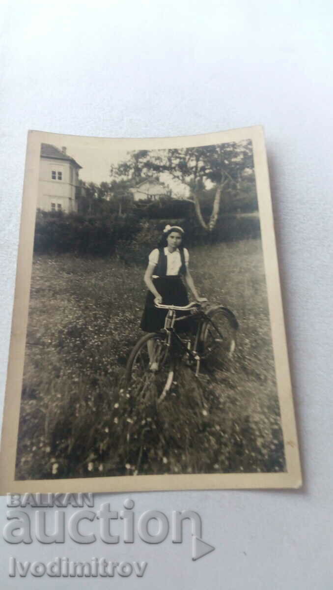 Foto Fată tânără cu bicicletă de epocă în iarbă 1944