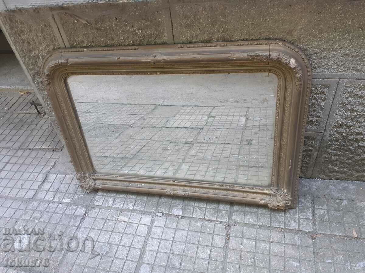 Old large and massive city mirror with baroque boards