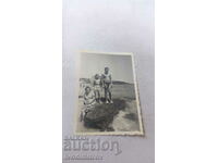 Photo Woman and two boys on a rock on the seashore