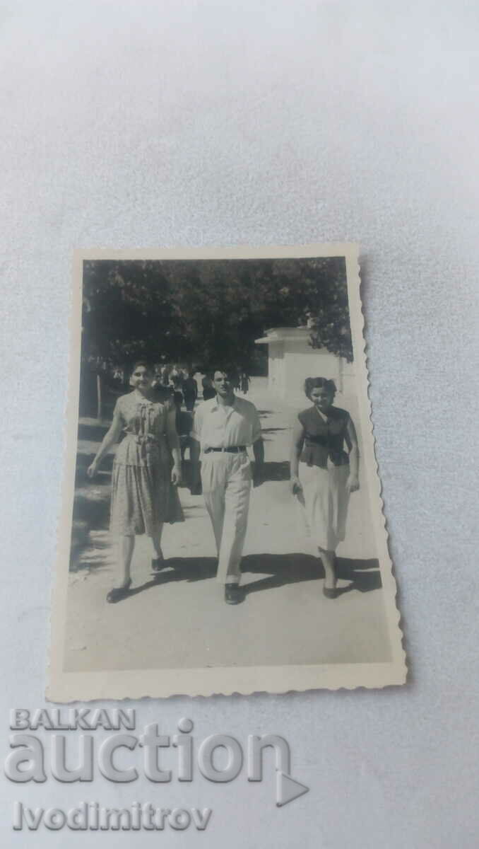 Photo A young man and two young women on a walk