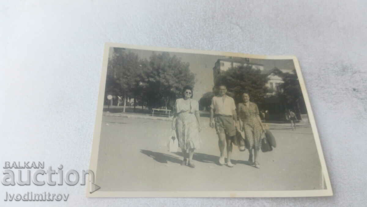 Photo of a man and two women on a walk
