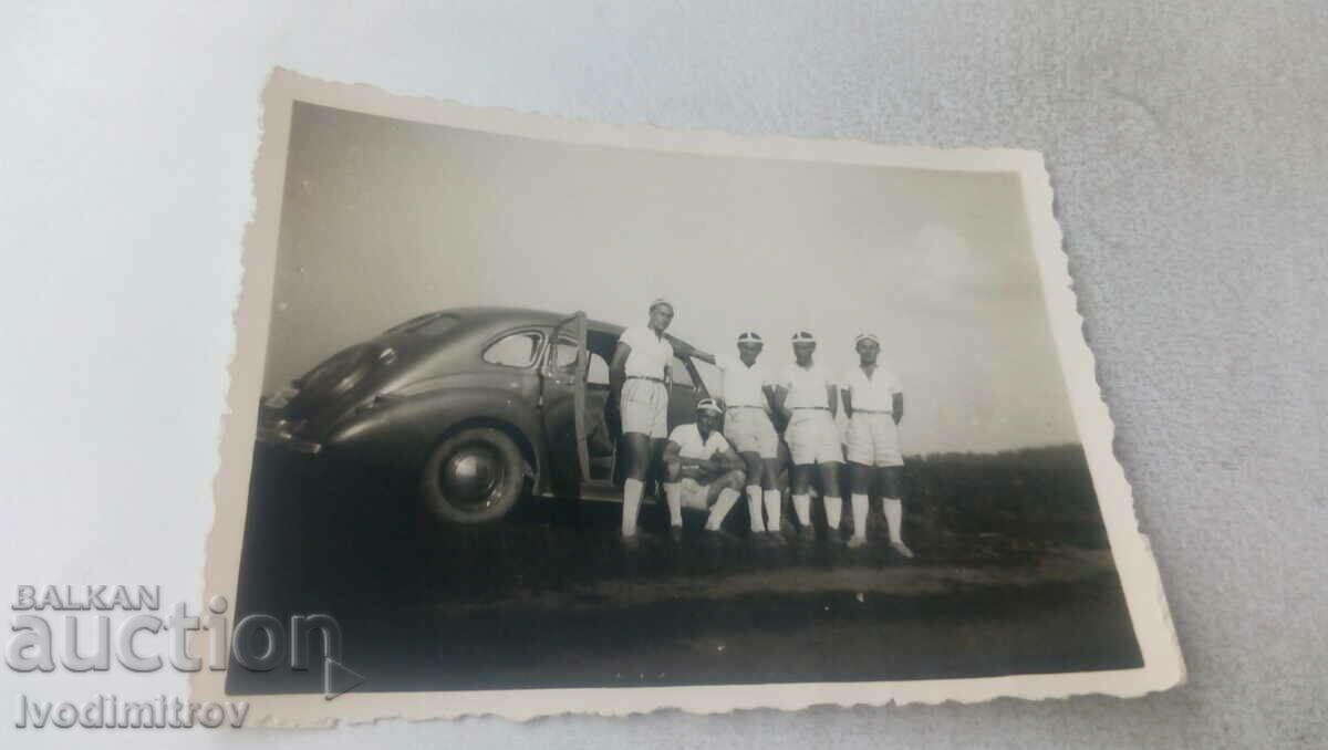 Снимка Петима млади мъже до ретро лек автомобил