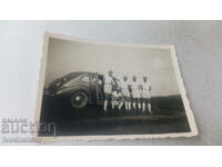 Φωτογραφία Πέντε νεαροί άνδρες δίπλα σε ένα vintage αυτοκίνητο