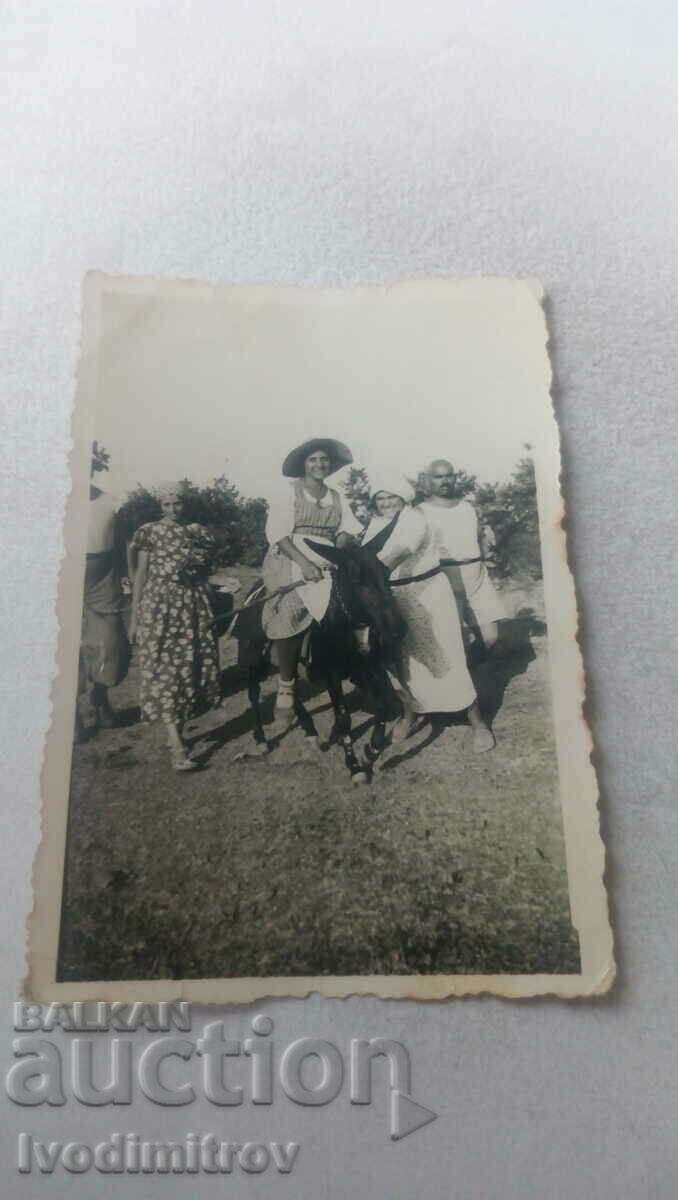 Снимка Мъж и три млади момичета с черно магаре