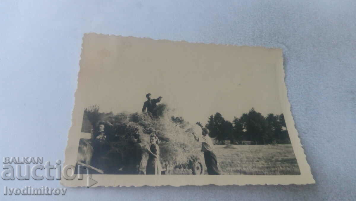 Photo Two men and two women with a wagon loaded with hay