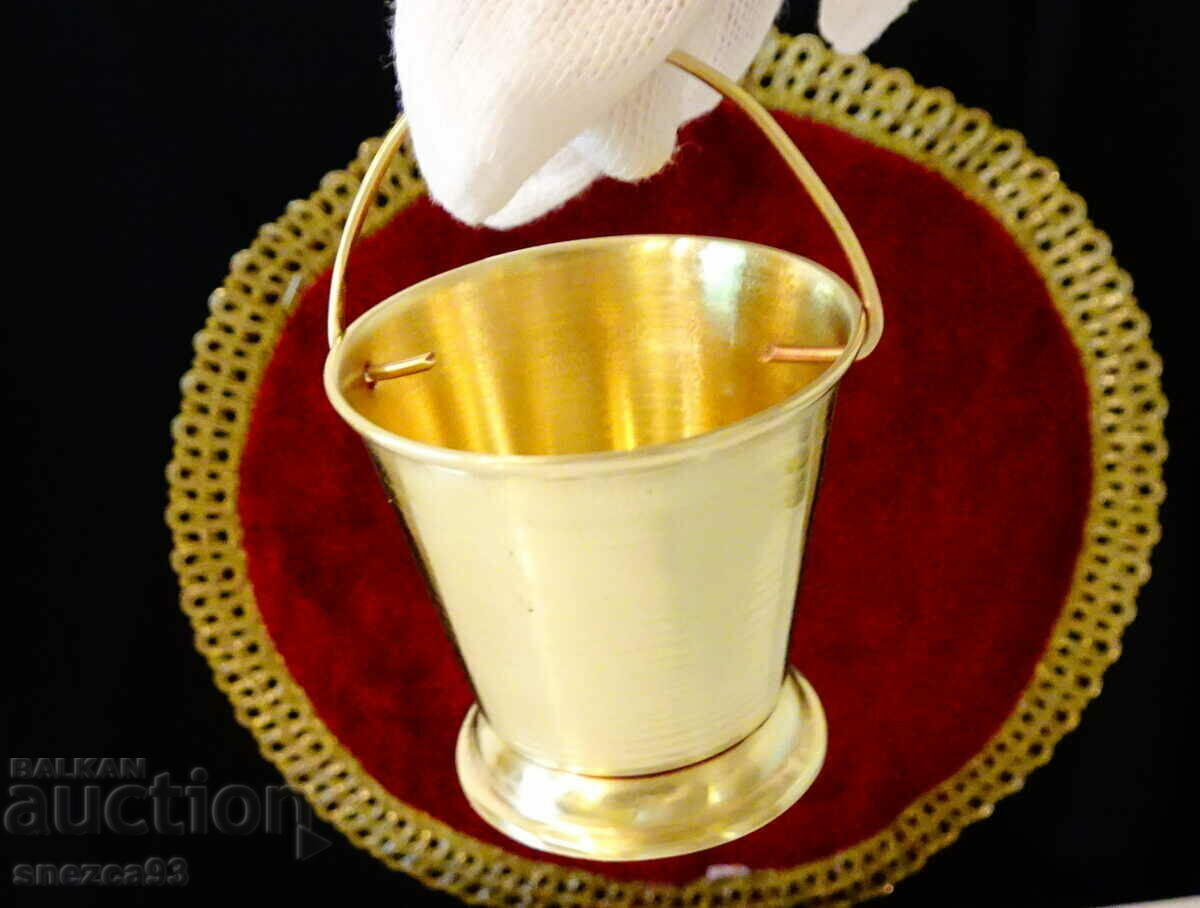 Brass cup with cauldron design.